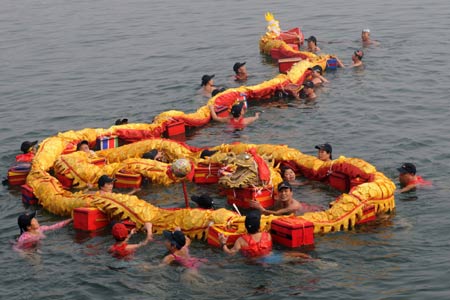 Swimmers perform dragon dance in water of Liujiang River to celebrate the traditional Chinese lunar Lantern Festival, in Liuzhou, southwest China's Guangxi Zhuang Autonomous Region, Feb. 7, 2009. [Li Bin/Xinhua] 