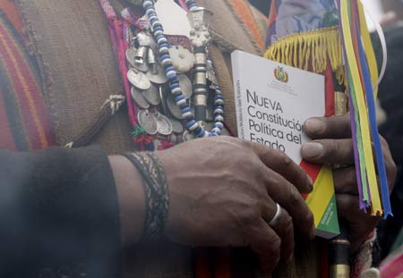 A Bolivian man in traditional clothes holds a copy of new Constitution during the promulgation of the new Constitution in El Alto, Bolivia, on Feb. 7, 2009.