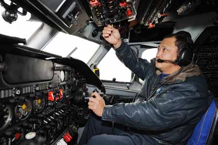 Captain Huo Qishu pilots the aircraft 'Transport 7' on the mission of artificial rainfall operations in Zhengzhou, capital of central China's Henan Province, Feb. 8, 2009. 