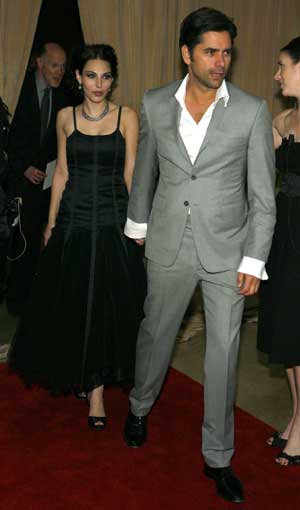 Actor John Stamos (R) and Leah Marsh arrive at the Recording Academy&apos;s Clive Davis pre-Grammy party in Beverly Hills, California Feb. 7, 2009. 