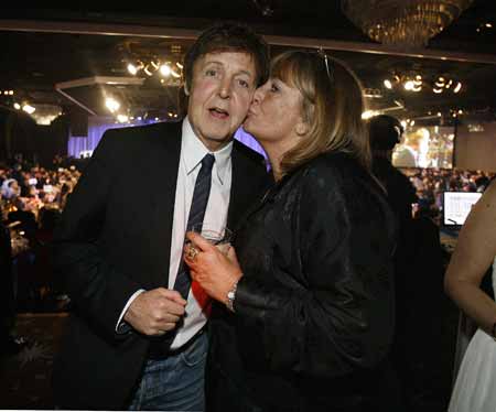 British singer Paul McCartney gets a kiss on the cheek by actress Penny Marshall at the 2009 Grammy Salute to Industry Icons event, honoring Clive Davis in Beverly Hills, California February 7, 2009.