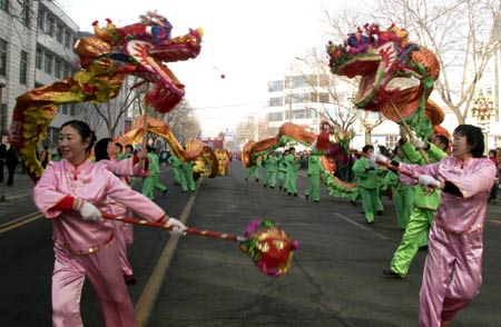 The women folk artists perform 'dragon dance' on a large-scale Yangge performance held in Wendeng City of east China's Shandong Province, Feb. 8, 2009. 