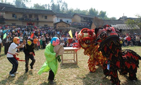 Local villagers enjoy a jovial get-together hall-stepping party by propitious lion-dance to liven up a jollification of the Lantern Festival, at a remote mountain-locked Bijiang Village, Zhaoping County, southwest China's Guangxi Zhuang Autonomous Region, Feb. 8, 2009. (Xinhua/Yu Xiangquan)