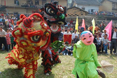 Local villagers enjoy a jovial get-together hall-stepping party by propitious lion-dance to liven up a jollification of the Lantern Festival, at a remote mountain-locked Bijiang Village, Zhaoping County, southwest China's Guangxi Zhuang Autonomous Region, Feb. 8, 2009. (Xinhua/Yu Xiangquan)