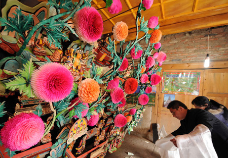 Tourists present Hada, a symbol of well-wishing of the Tibetan ethnic group, to the ghee flowers artworks displayed at the Taer Monastery in Huangzhong County, northwest China's Qinghai Province, Feb. 8, 2009. 