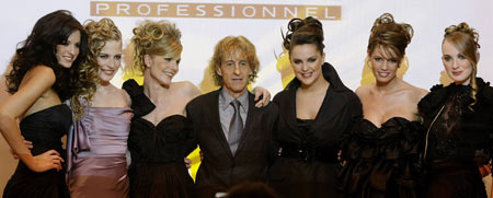 Models, including Mireia Verdu (3rd L), display creations by hair stylist Josep Pons (C) during the presentation of a new line of 'Texture Expert' hair products from L'Oreal in central Barcelona Feb. 9, 2009. The grid lines are caused by a light projection at the show. 