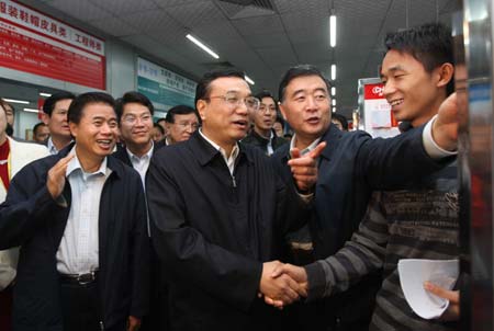 Chinese Vice Premier Li Keqiang (C), who is also a member of the Standing Committee of the Political Bureau of the Communist Party of China Central Committee, shakes hands with a job seeker at a personnel market in Dongguan, south China's Guangdong Province, Feb. 8, 2009. Li Keqiang paid a visit to Guangdong Province from Feb. 6 through 9. [Liu Weibing/Xinhua]