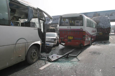 Damaged vehicles are seen at the site of a traffic accident caused by heavy fog on the segment of Jingfu Highway in Tai'an City of east China's Shandong province, Feb. 10, 2009. More than 100 vehicles collided into each other due to heavy fog on Tuesday morning, which caused some passengers injured. (Xinhua/Gong Hui)