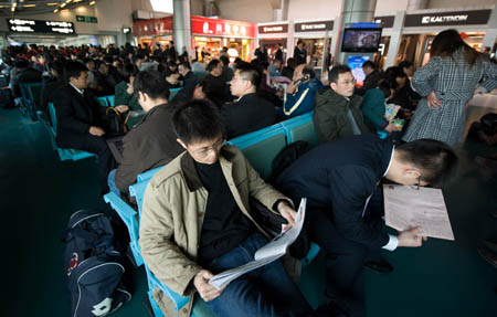 Passengers wait to board the planes at the Nanjing Lukou Airport in Nanjing, east China's Jiangsu Province, Feb. 10, 2009. A number of flights were delayed owing to the thick fog blanketing Nanjing on Tuesday. (Xinhua/Jin Liangkuai)