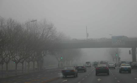 Vehicles run in fog in Dalian, northeast China's Liaoning Province, Feb 11, 2009. Heavy fog hit Dalian on Wednesday, with a visibility of about 150 meters. [Yan Ping/(Xinhua]