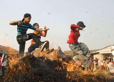 Children jump over bonfire in Xidong Village of Zhanlong Township in Puning City, south China's Guangdong Province, Feb. 10, 2009. As a local folk custom, the villagers here light the bonfire outdoor for people to leap over, which represents the passing of the year and entering in the new year. [Ma Ka/Xinhua] 