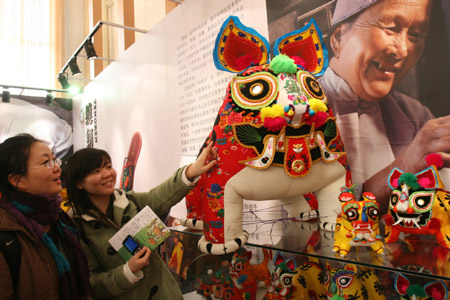 Two Chinese girls view exhibits at an exhibition intending to showcase the country's progress in protecting intangible cultural items in Beijing, capital of China, Feb. 10, 2009. (Xinhua/Chen Xiaogen) 
