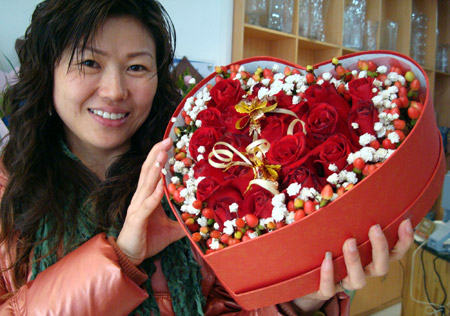 A Chinese woman showcases a box of roses bought for the upcoming St. Valentine's Day in Suzhou City, east China's Jiangsu Province, Feb. 10, 2009. Roses are sold well with the approach of the St. Valentine's Day, which falls on Feb. 14. (Xinhua/Wang Jiankang)