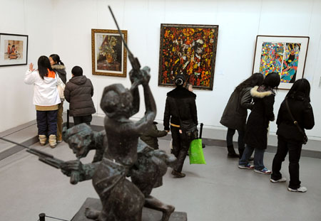 Visitors look at paintings drawn by university students at an art exposition held in Nanjing, east China&apos;s Jiangsu Province, Feb. 10, 2009. The 2nd National Arts Exposition & Performance for University Students, opened here on Tuesday, displayed over 400 works of university students around China, including paintings, sculptures, photos and other craftworks. (Xinhua/Sun Can)(