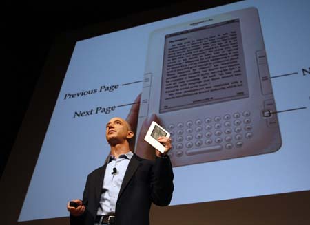 Amazon.com founder and CEO Jeff Bezos holds the new Kindle 2 electronic reader at a news conference in New York where the device was introduced, February 9, 2009. The Kindle 2, the latest incarnation of the digital book reader is a slimmer version with more storage and a feature that reads text aloud to users. 