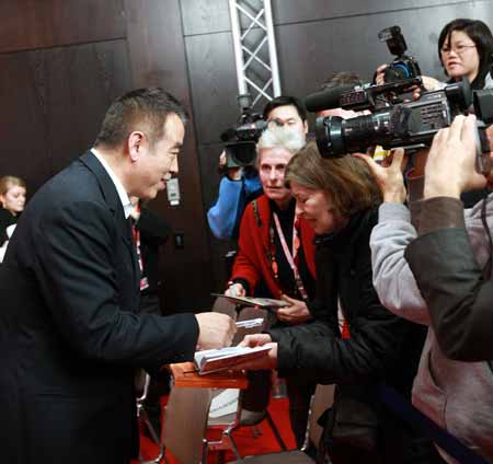 Chinese director Chen Kaige (L) signs for fans at the press conference for the film 'Forever Enthralled' at the 59th International Film Festival Berlin (Berlinale) in Berlin, Germany, Feb. 10, 2009.