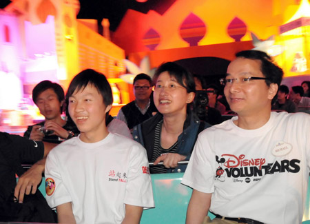 Dai Guohong (L, Front), a boy who was crippled in the 5.12 massive earthquake in southweat China's Sichuan Province, plays at the Disneyland accompanied by a handicapped employee (R, Front) in Hong Kong, China, on Feb. 10, 2009.