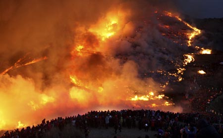 People look at burning pampas grass at Hwawang mountain in Changnyeong, about 275 km (170 miles) southeast of Seoul, Feb. 9, 2009, in celebration of 'Jeongwol Daeboreum', or Great Full Moon, which is a Korean traditional holiday that celebrates the first full moon of the lunar calendar. 