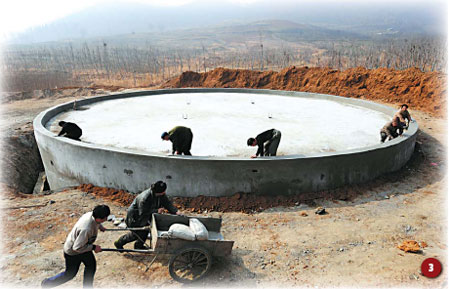 Villagers work on the construction of a water tank in Nanbao, Henan province. When completed the new tank, which is 3 km away from the village, will ensure that 5,000 residents have better access to drinking water. [Gao Shanyue/China Daily] 