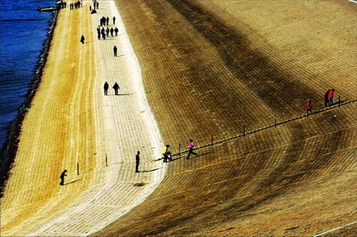 Luhun reservoir, the second largest reservoir in central China's Henan province, with a capacity of 1.3 billion cubic meters of water, now holds only 200 million cubic meters of water. Local residents take a walk along the dry dam. [Southern Metropolis Daily] 