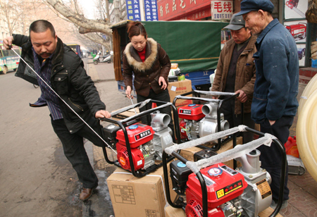 A farmer shops for water pump in Baofeng, central China's Henan Province, Feb. 11, 2009. Worst drought in decades has hit China's northern wheat-growing belt this spring. Affected residents were busy in fighting against the drought and reducing damages. [Wang Shuangzheng/Xinhua] 