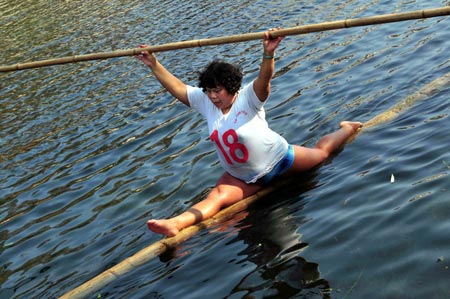 A woman splits on a floating bamboo stick on the Huaxi River in Guiyang, capital of southwest China's Guizhou Province, Feb. 11, 2009. [Qin Gang/Xinhua]