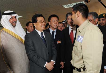 Visiting Chinese President Hu Jintao (2nd L front) talks with a staff member as he visits a cement production project constructed by Chinese companies in Riyadh, Saudi Arabia, Feb. 11, 2009. (Xinhua/Rao Aimin)