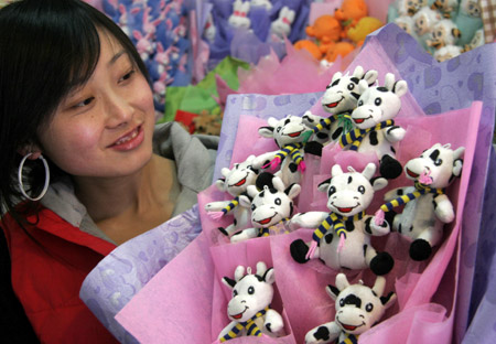 A saleswoman shows a bouquet of cow dolls in a shopping mall in Weihai City, east China's Shandong Province, Feb. 11, 2009. Various Valentine's Day gifts are sold well with the approach of the St. Valentine's Day, which falls on Feb. 14. 