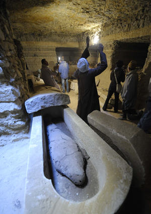 Archeologists work beside a mummy inside a burial chamber at Saqqara, 30 km south of Cairo, capital of Egypt, on Feb. 11, 2009.
