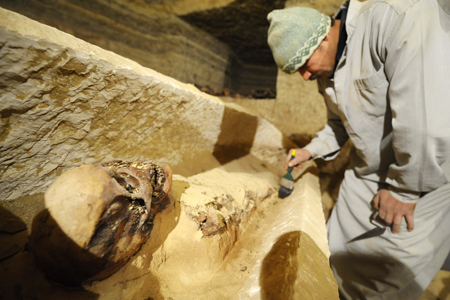 Archeologists work beside a mummy inside a burial chamber at Saqqara, 30 km south of Cairo, capital of Egypt, on Feb. 11, 2009. (Xinhua/Zhang Ning)
