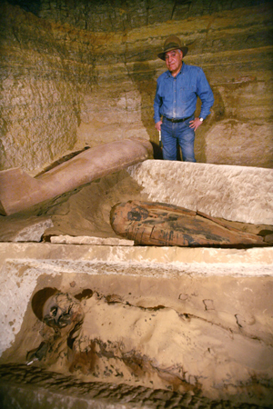 Zahi Hawass, Secretary General of the Egyptian Supreme Council of Antiquities, stands beside the newly-found mummies, wooden coffins, and limestone sarcophagi at Saqqara, 30 km south of Cairo, capital of Egypt, on Feb. 11, 2009.