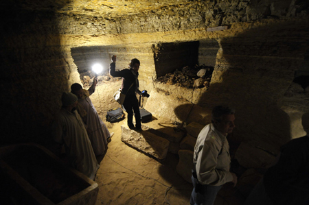 A journalist walks inside a burial chamber at Saqqara, 30km south of Cairo, capital of Egypt, on Feb. 11, 2009.(