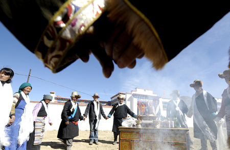 Tibetan villagers dance during a celebration for moving into new houses in Kunggar Town of Maizhokunggar County in Lhasa, capital of southwest China's Tibet Autonomous Region, Feb. 11, 2009.