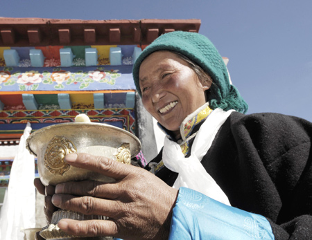 A Tibetan villager toasts during a ceremony for moving into her new house in Kunggar Town of Maizhokunggar County in Lhasa, capital of southwest China's Tibet Autonomous Region, Feb. 11, 2009. 