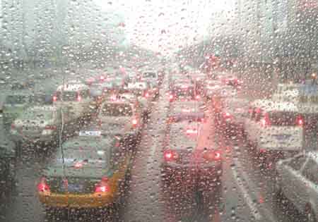 Photo taken on Feb. 12, 2009 shows vehicles on a street seen through a piece of glass covered with raindrops in Beijing, China. Beijing welcomed its first rain in 110 days on Thursday morning, but experts say it was too little to end the city's lingering drought.