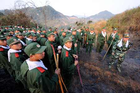 Armed Policemen are going to put out forest fire in Shaxian County of Sanming City, 270 km from Fuzhou, capital of southeast China's Fujian province Feb. 13, 2009. A fire in the province was under control Friday morning after burning for 22 hours and devastating a swath of mountain forests bordering farmhouses, local authorities said. (Xinhua/Zhang Guojun)