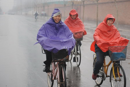 Bicyclers ride in rain in Shijiazhuang, North China's Hebei province Thursday February 12, 2009. Most of the northern Chinese provinces welcomed a rainy day Thursday, as the country's worst drought in decades continued to batter the region. [Xinhua] 