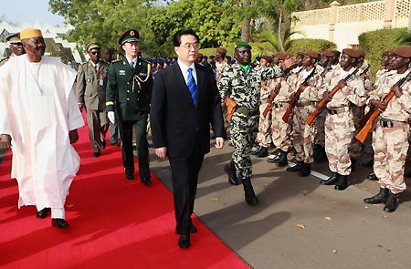 Chinese President Hu Jintao (C) and Malian President Amadou Toumany Toure (L) review the honor guard during a welcoming ceremony in Bamako, Mali, on Feb. 12, 2009. 