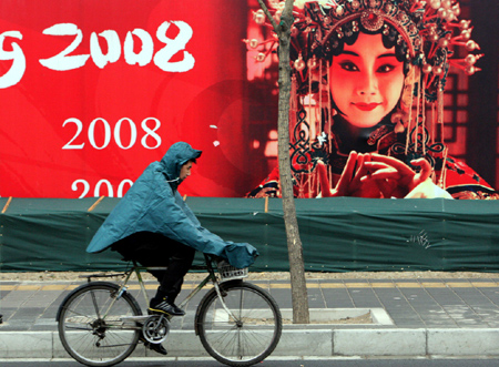 A man in raincoat rides on a road in Beijing, capital of China, on Feb. 12, 2009. Beijing welcomed its first rain in 110 days on Thursday morning, but experts say it was too little to end the city's lingering drought.