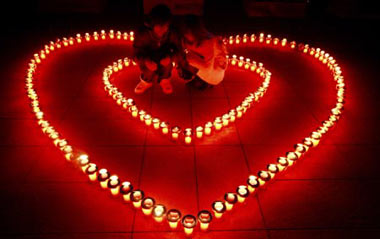 A pair of lovers squat in the 'hearts' shaped by candles during an activity for the upcoming Valentine's Day in Enoshima Island of Kanagawa Prefecture, Japan, Feb. 12, 2009.