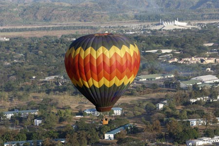 A hot air balloon takes off over the industrial zone during the start of the 14th Philippine International Hot Air Balloon Week at Clark airbase in Pampanga province, north of Manila, February 12, 2009. At least 25 countries are expected to fill the skies of Pampanga with a barrage of color as they participate in the ballooning event.