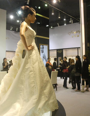 A model displays a wedding dress at the 15th Shanghai International Wedding Photographic Equipment Exhibition in Shanghai, east China, Feb. 12, 2009. The four-day exhibiton opened on Thursday with about 500 enterprises from home and abroad attending. 