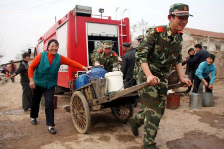 Soldiers help the villagers to transport water in Lieshan Township in Huaibei City, east China&apos;s Anhui Province, Feb. 12, 2009. Fire engines were sent to deliver water for residents in the villages of Lieshan Township. Huaibei city has suffered from drought since October last year. (Xinhua/Wan Shanchao)