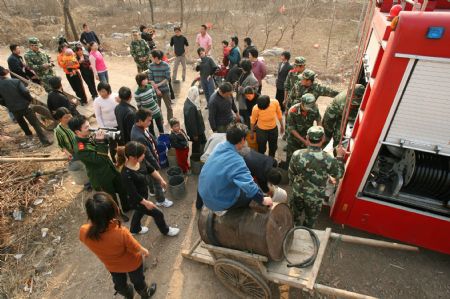 Villagers get water from a fire engine in Hualou Village of Lieshan Township in Huaibei City, east China&apos;s Anhui Province, Feb. 12, 2009. Fire engines were sent to deliver water for residents in the villages of Lieshan Township. Huaibei city has suffered from drought since October last year.