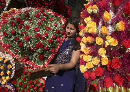 A vendor carries a heart-shaped rose bouquet to arrange it for sale on the eve of Valentine&apos;s Day, in the northern Indian city of Chandigarh February 13, 2009. 