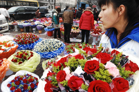 A saleswoman arranges bouquets of roses for the Valentine's Day at a flower market in Dalian, northeast China's Liaoning Province, Feb. 14, 2009. Various kinds of roses sell well in the city on Saturday, the Valentine's Day. [Xinhua]