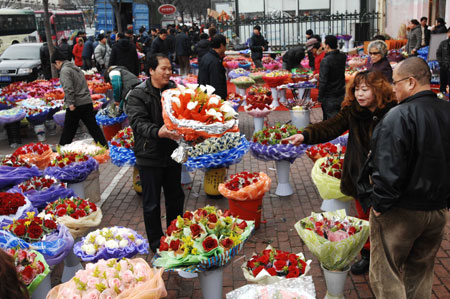 Customers buy roses for the Valentine's Day at a flower market in Dalian, northeast China's Liaoning Province, Feb. 14, 2009. Various kinds of roses sell well in the city on Saturday, the Valentine's Day. [Xinhua]