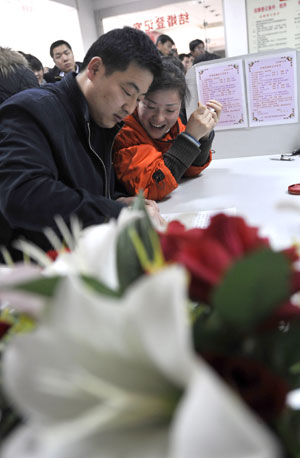 A couple get married at a marriage registration center in Jinan, capital of east China's Shandong Province, Feb. 14, 2009. Lots of couples got registered here on the Valentine's Day. [Xinhua]