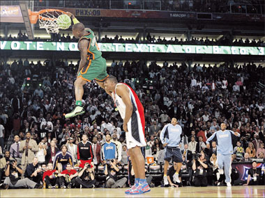 Nate Robinson of the New York Knicks jumps over Orlando's Dwight Howard during the slam dunk contest at NBA All-Star Weekend in Phoenix. He won the event. [Shanghai Daily]