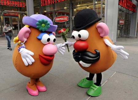 Mr. Potato Head (R) gives Mrs. Potato Head flowers on Valentine's Day on the street outside of Hasbro's American International Toy Fair showroom in New York February 14, 2009.[Xinhua/Reuters]